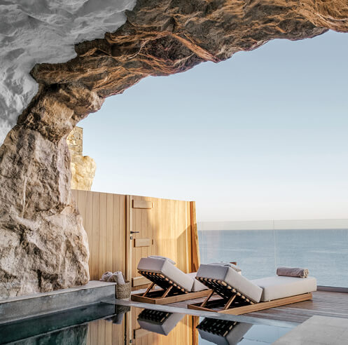 ACRO Suites feature hill-like forms leaning out from above the rocky Cretan coastline