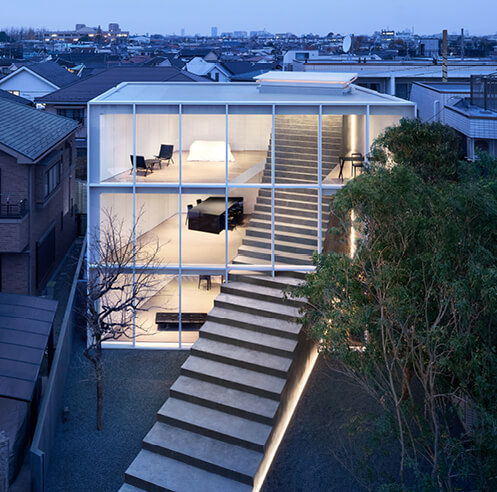Nendo cuts a sweeping staircase through the facade of a two-family home in Tokyo