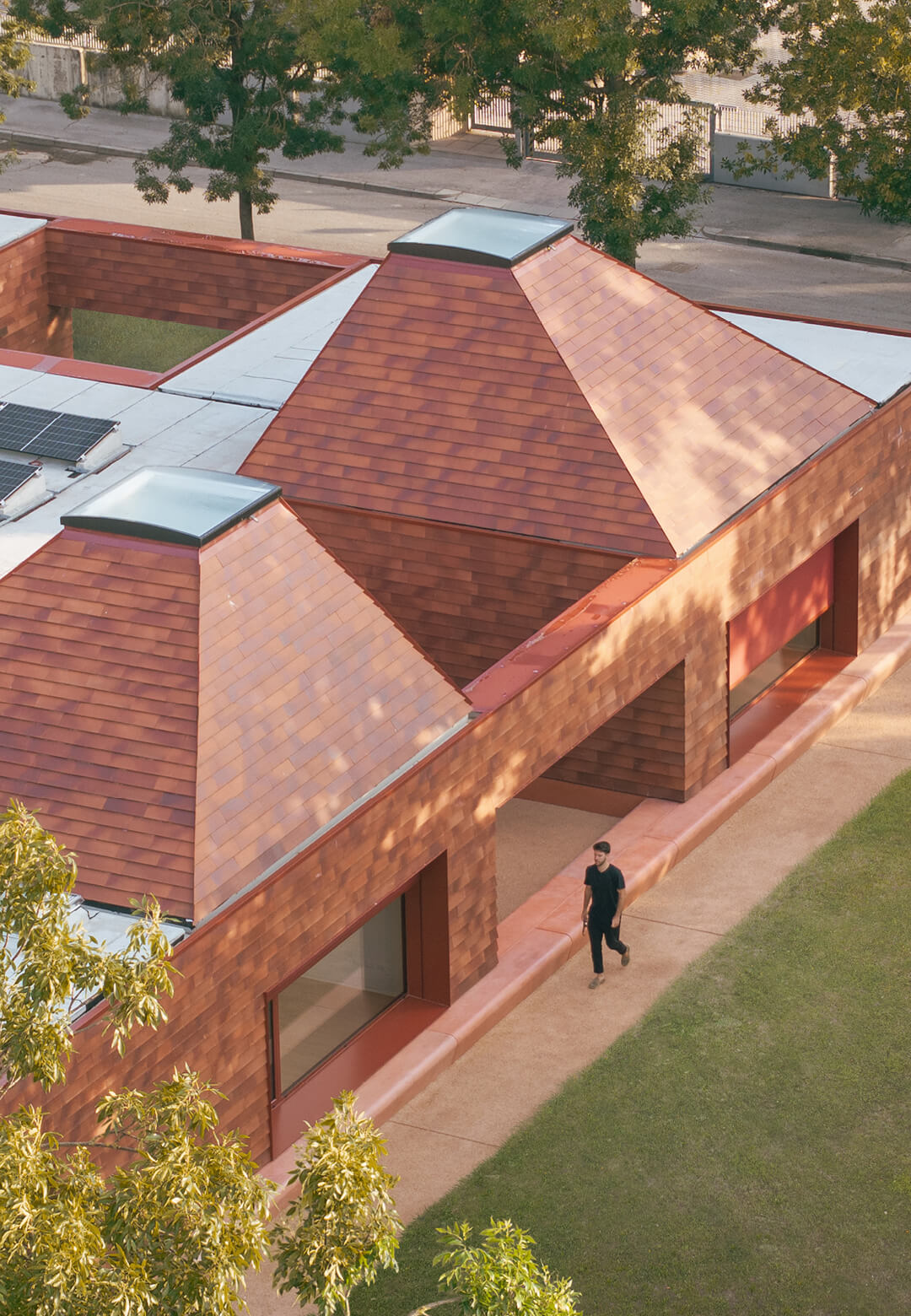 A single terracotta block punctuated with voids and pyramid roofs forms an immersive learning space | Kinder Rain | AACM &ndash; Atelier Architettura Chinello Morandi | STIRworld
