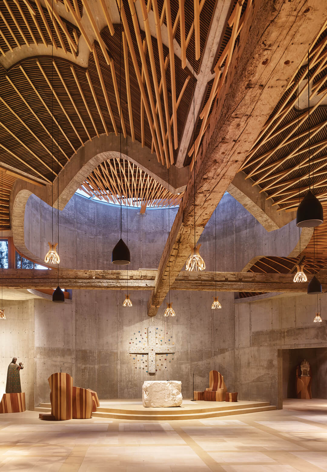 Interiors of the San Giacomo Apostolo Church, with its exposed concrete walls and lightweight organic roof | San Giacomo Apostolo Church and Parish Complex | EMBT | STIRworld