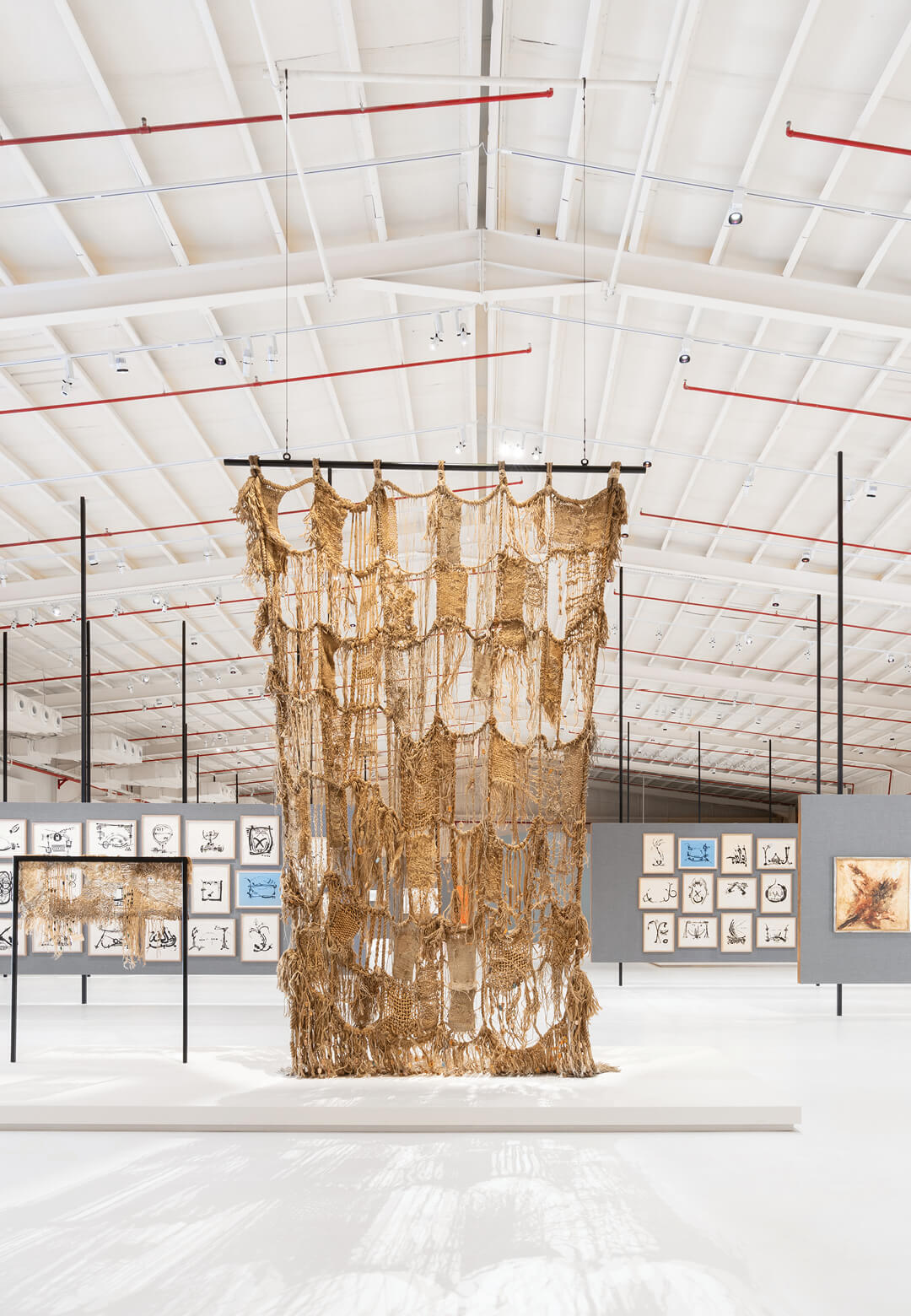 Installation view of <i>Life is a Woven Carpet</i>, 1995, front left and <i>Life is a Woven Carpet</i>, 2001, and works by Samia Zaru, Abdulrahman Al-Soliman and Hind Nasser, <i>After Rain</i>
