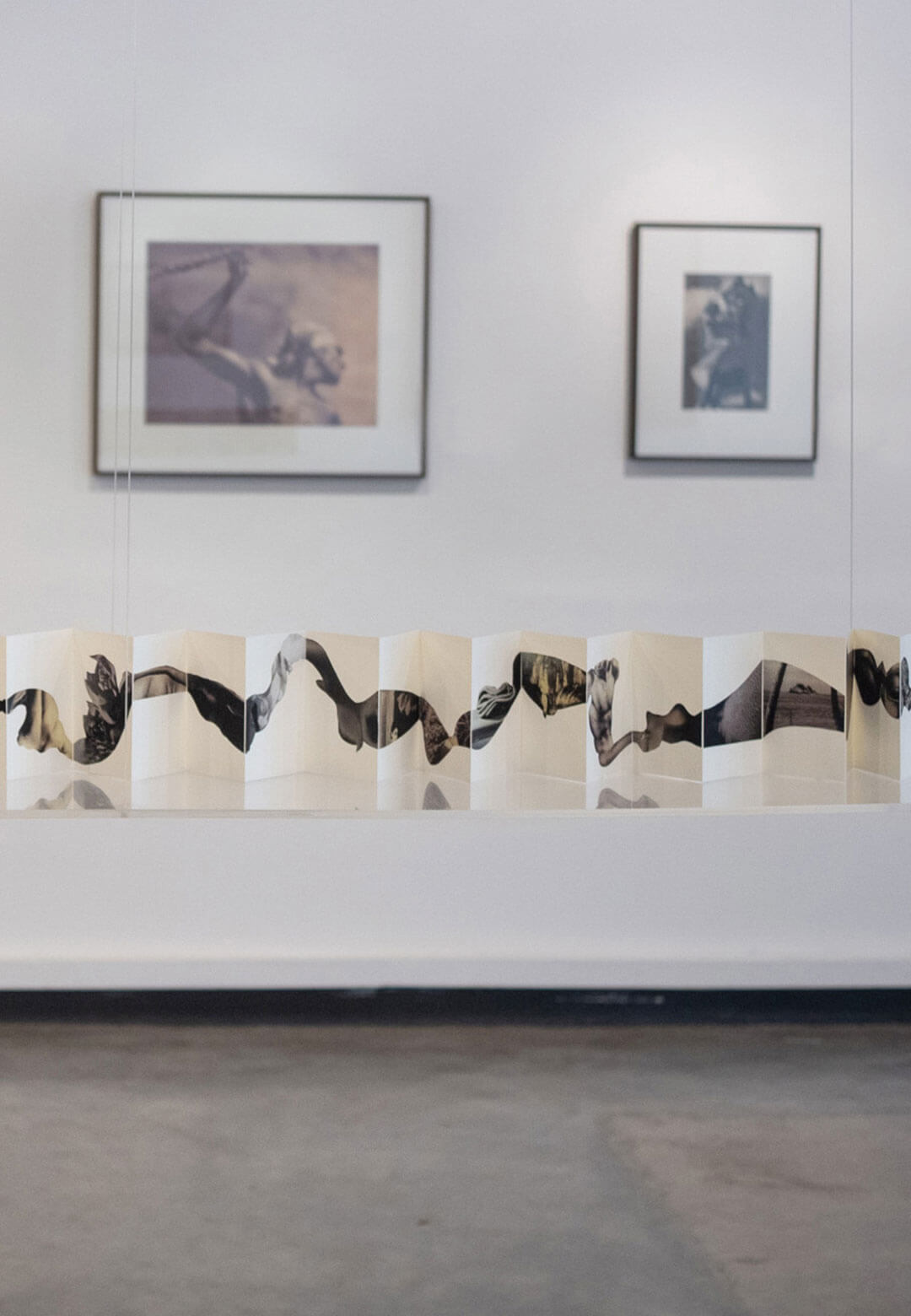 : Installation view of Lionel Wendt Remixed by Muhanned Cader at KALA South Asia 2024, against the backdrop of (from left to right) Silence (n.d.), Title Unknown (n.d.), and Breeze by Gaslight (n.d.)