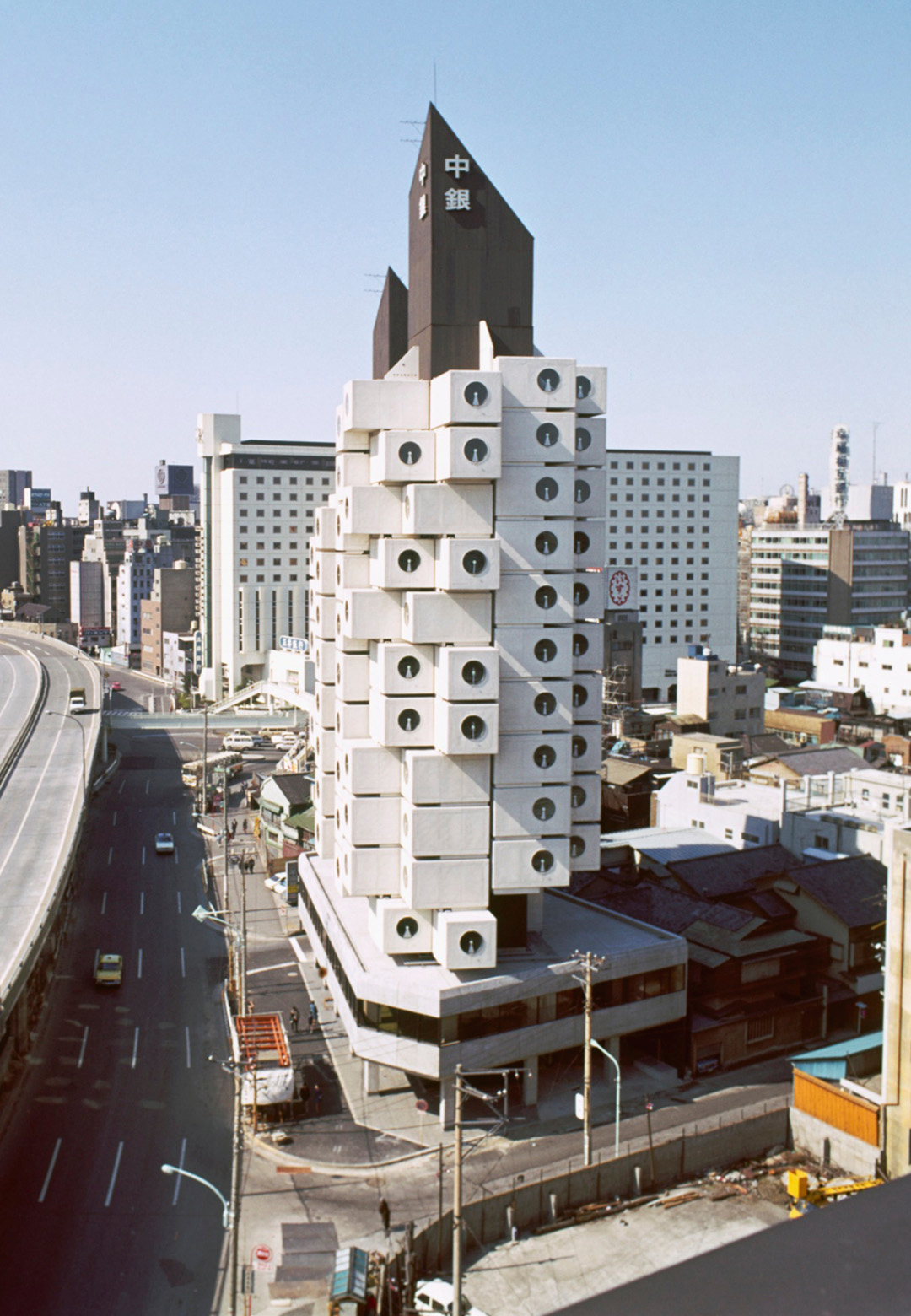 (L-R) Exterior view of Nakagin Capsule Tower, Tokyo, Kisho Kurokawa, Architect & Associates, 1972; Installation view of ‘The Many Lives of the Nakagin Capsule Tower’ at The Museum of Modern Art | The